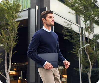 Ein Geschäftsmann trägt den tragbaren Monitor ZenScreen MB16QHG bei sich