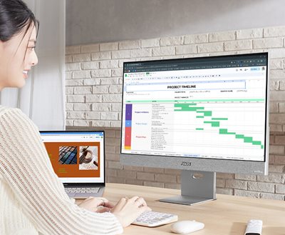 Eine junge Berufstätige arbeitet an ihrem Laptop und verwendet den ASUS ZenScreen Smart Monitor MS27UC als größeren zweiten Bildschirm.