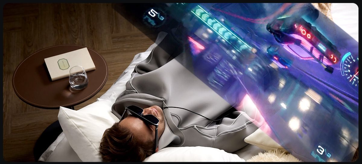 Ein Mann liegt auf dem Bett und genießt sein intensives Spielerlebnis mit der ROG XREAL R1 Gaming-AR-Brille und ROG Xbox Ally.